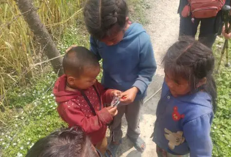 Bambini nepalesi che giocano con la bussola